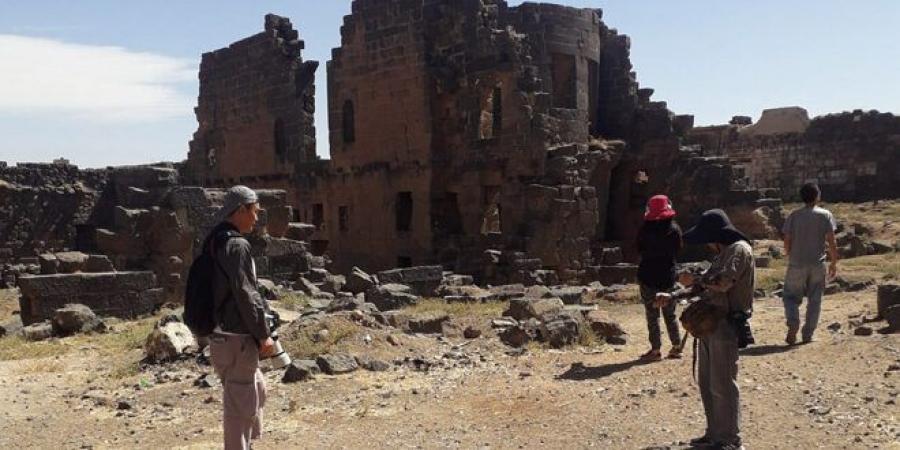 مجموعة سياحية من جنسيات مختلفة تزور مدينة بصرى الشام وتطلع على آثارها