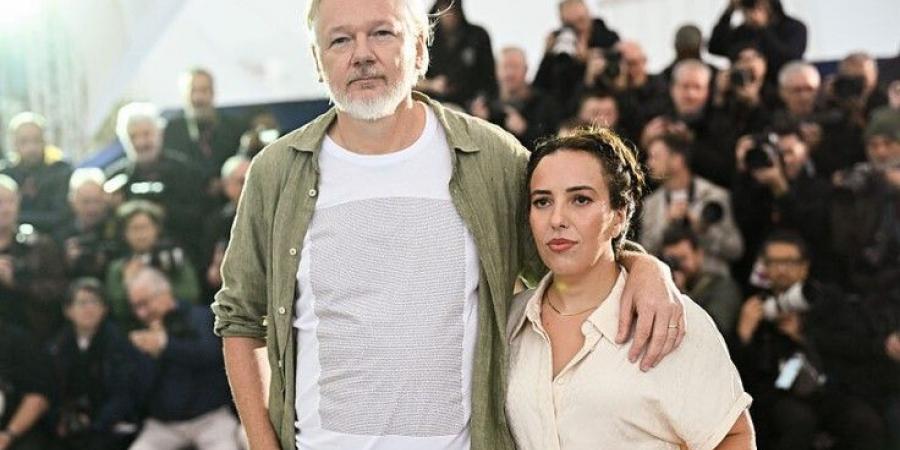 مؤسس "ويكليكس" يرتدى قميصا يحمل أسماء 5 آلاف طفل قتلوا في غزة